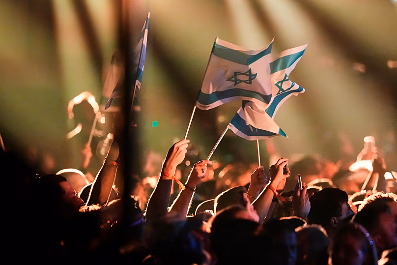 Des drapeaux israéliens brandis par des membres de la foule alors que Noam Bettan d'Israël se produit lors de la première demi-finale du 70e Concours Eurovision de la chanson à Vienne, le 12 mai 2026.