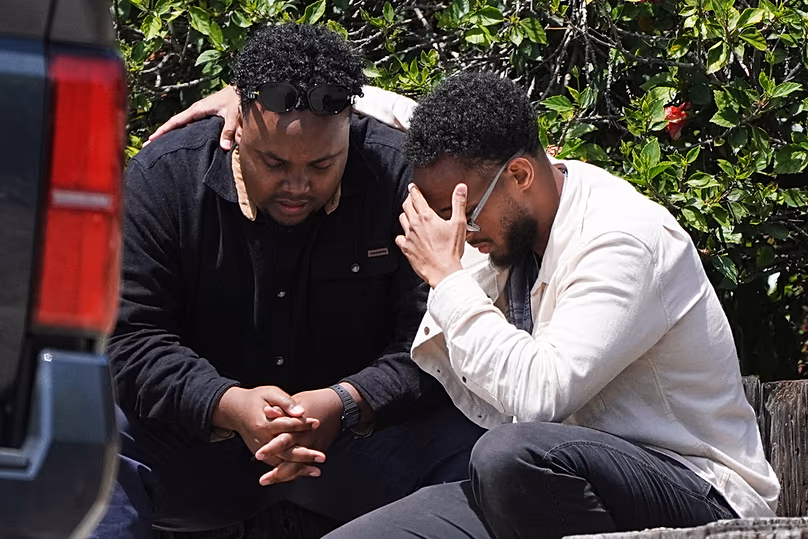 Deux hommes s'embrassent sur les lieux d'une fusillade devant le Centre islamique de San Diego, le lundi 18 mai 2026, à San Diego