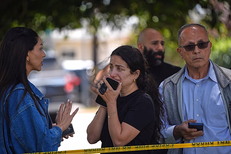 Des gens se tiennent derrière un ruban adhésif de la police sur les lieux d'une fusillade devant le Centre islamique de San Diego, le lundi 18 mai 2026, à San Diego.