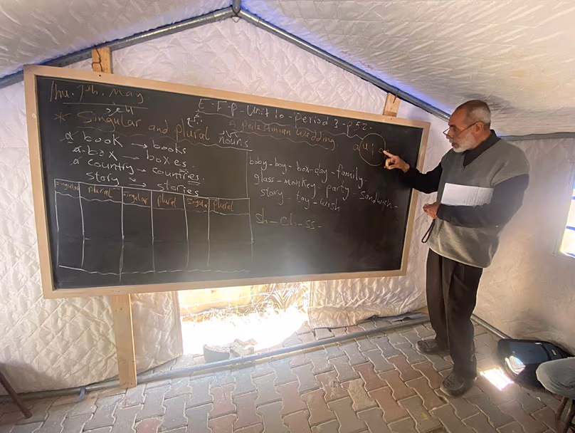 Un enseignant explique les cours dans une tente éducative pour étudiants déplacés à Gaza