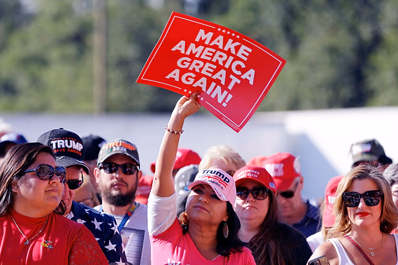 Un participant brandit une pancarte MAGA pendant que la foule attend Donald Trump, le 2 novembre 2023, à Houston. (Photo AP/Michael Wyke)