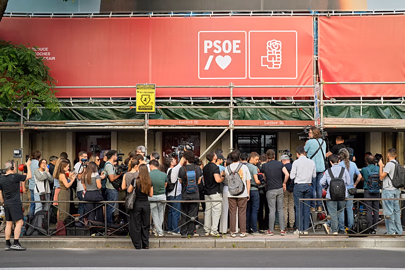 Des journalistes se rassemblent devant le siège du Parti socialiste au pouvoir en Espagne alors que la police fouille le bâtiment à Madrid, le 27 mai 2026.