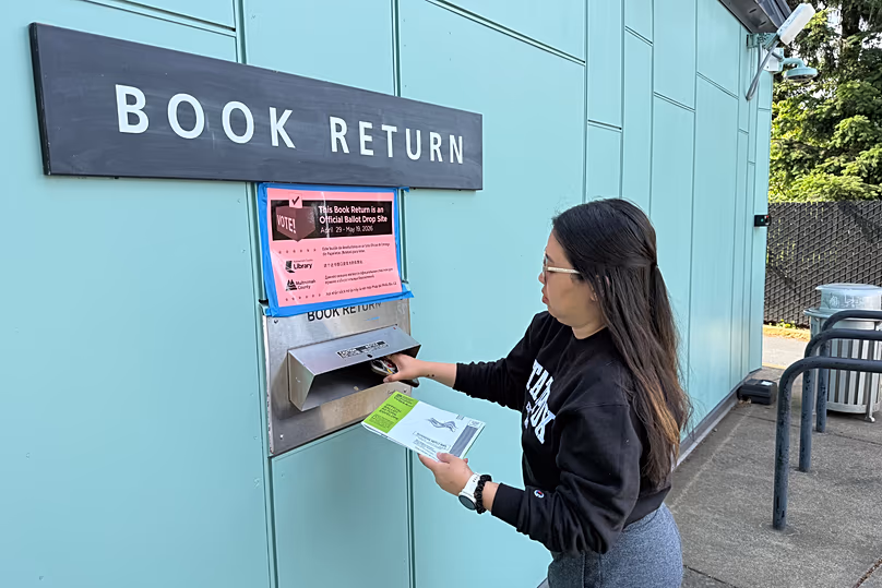 Un électeur dépose son bulletin de vote dans une bibliothèque de Portland, le 19 mai 2026.