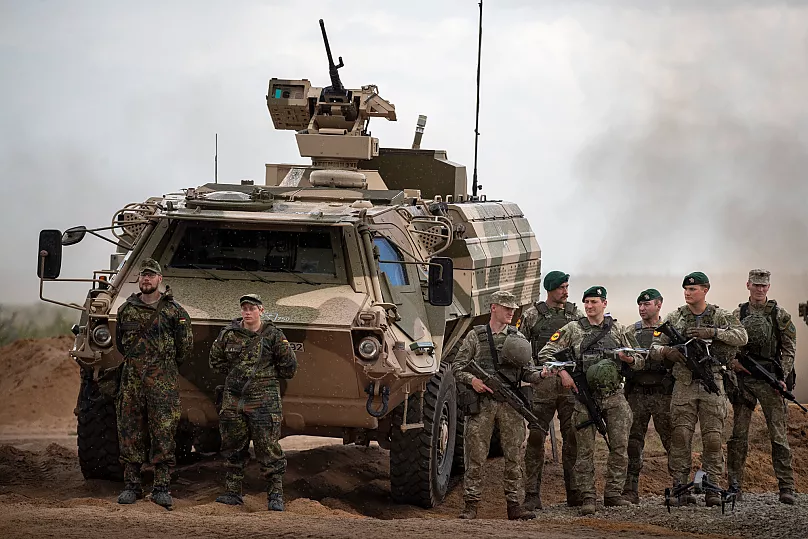 Des soldats allemands de la Bundeswehr se tiennent à côté d'un véhicule militaire blindé de l'armée allemande lors d'un exercice conjoint germano-lituanien près de Vilnius, le 29 mai 2024.
