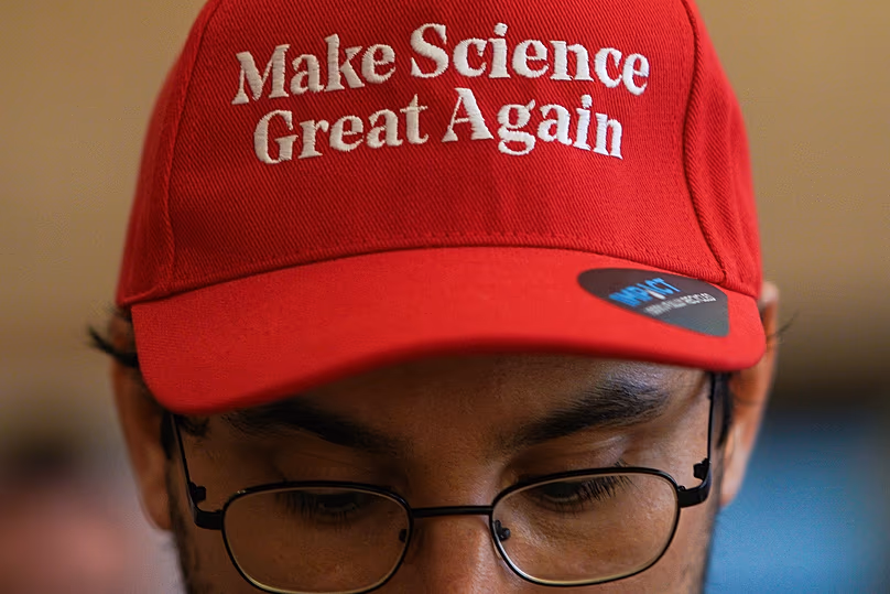 Un homme porte un chapeau sur lequel est écrit « Make Science Great Again » lors d