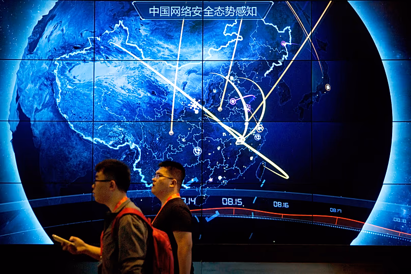 Les participants passent devant un écran électronique montrant les récentes cyberattaques en Chine lors de la Conférence chinoise sur la sécurité Internet à Pékin, le 12 septembre 2017.