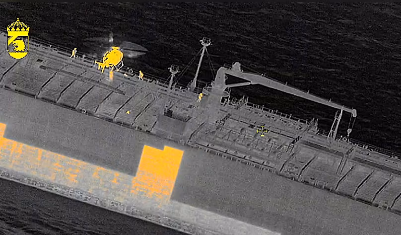 Sur cette image réalisée avec une caméra thermique, des responsables suédois montent à bord du pétrolier « Sea Owl I » au large de Trelleborg, le 12 mars 2026.