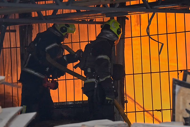 Des pompiers travaillent sur le site d'un bâtiment en feu après une attaque de missile russe à Kiev, en Ukraine, le mardi 2 juin 2026. (AP Photo/Efrem Lukatsky)