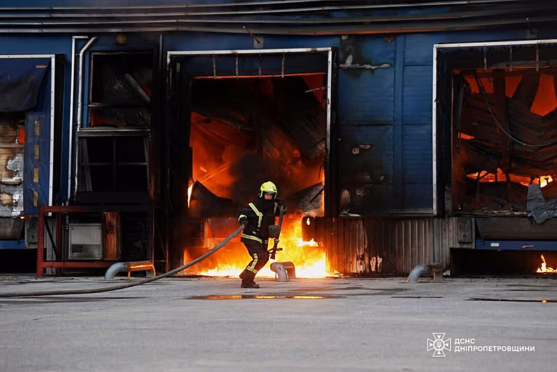 Un secouriste éteint l'incendie d'un entrepôt endommagé après une frappe russe dans la région de Dnipropetrovsk, le 4 juin 2026.