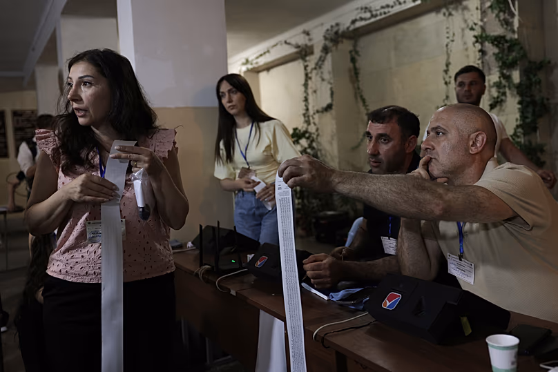 Les membres de la commission électorale se préparent à compter les bulletins de vote dans un bureau de vote lors des élections législatives à Erevan, le 7 juin 2026.