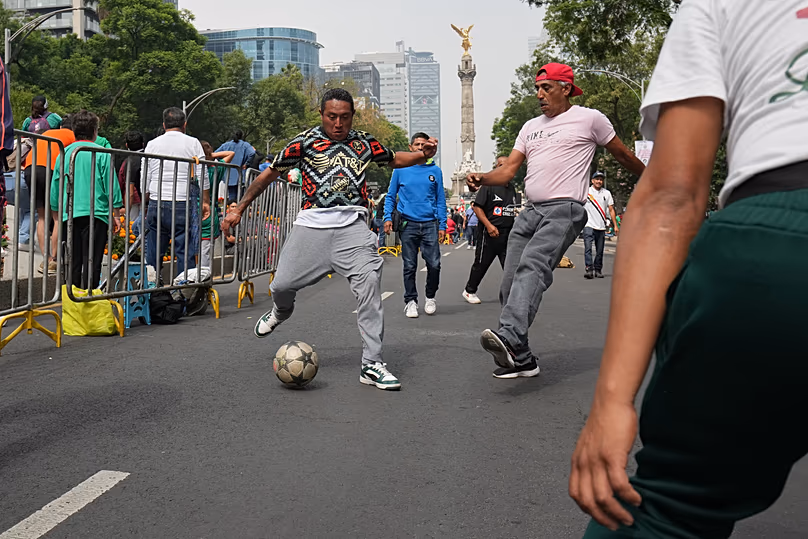 Les fans de football jouent avec un ballon avant de participer à une vague mexicaine le long de l'avenue Reforma à Mexico, le samedi 6 juin 2026, avant la Coupe du Monde de la FIFA.