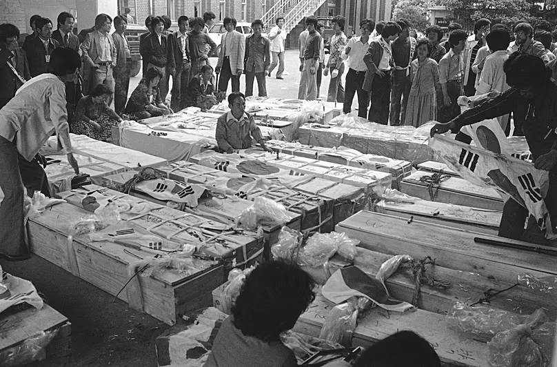 Des familles et des proches se rassemblent autour des cercueils des manifestants morts au siège provincial de Gwangju, le 23 mai 1980.