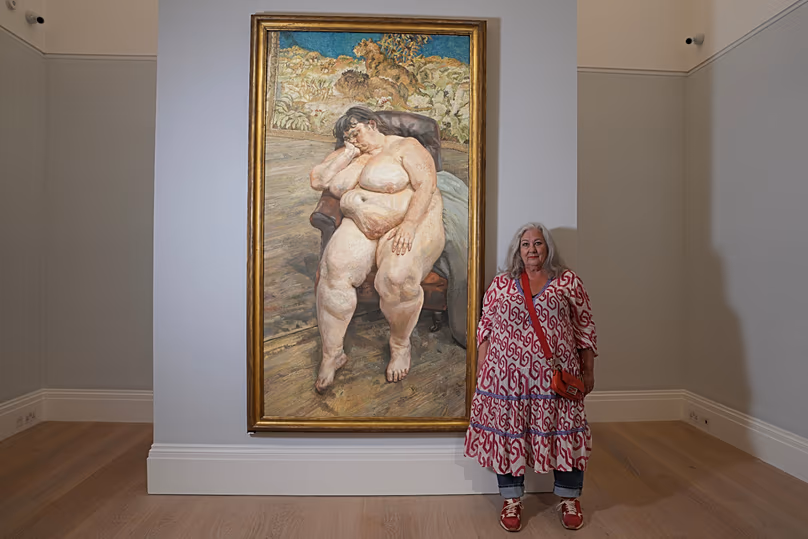Sue Tilley, modèle du peintre britannique Lucian Freud, pose devant le tableau d'elle peint par Freud, intitulé "Dormir près du tapis du lion".
