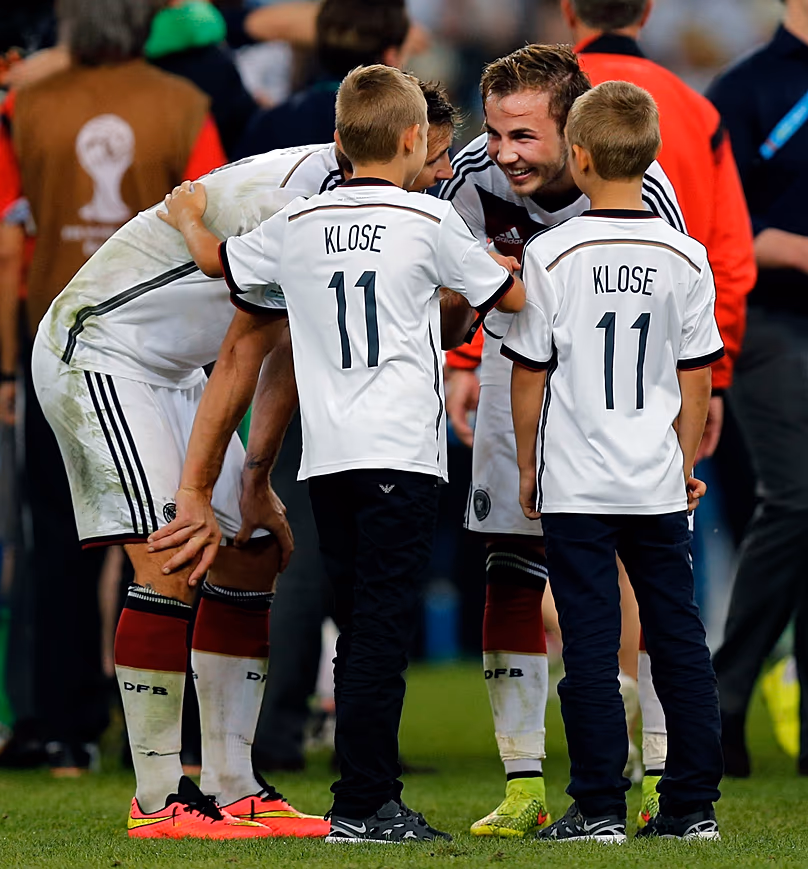 Le footballeur Mario Götze s'entretient avec les enfants de son coéquipier Miroslav Klose après la finale de la Coupe du monde entre l'Allemagne et l'Argentine en juillet 2014.