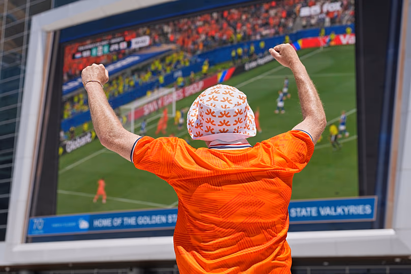 Un fan néerlandais célèbre le but de son équipe contre le Japon alors qu'il assiste à la projection publique du match de Coupe du monde contre le Japon à San Francisco, le dimanche 14 juin 2026.