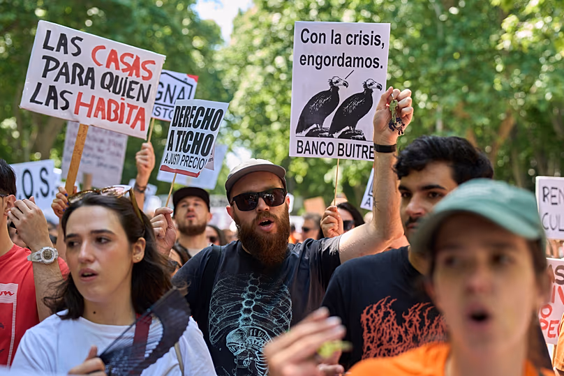 Plusieurs personnes brandissent une banderole sur laquelle on peut lire : « Des maisons pour ceux qui y vivent » lors d