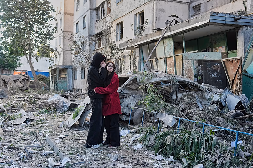 Les gens réagissent en regardant le site de la frappe de missile russe qui a touché un immeuble résidentiel à Kiev, en Ukraine, le mardi 2 juin 2026. (AP Photo/Efrem Lukatsky)
