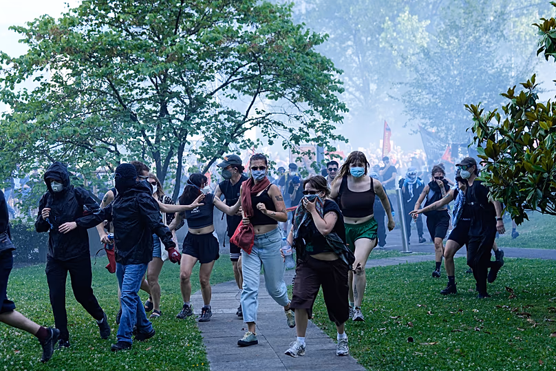 Les manifestants se dispersent dans une zone herbeuse lors d