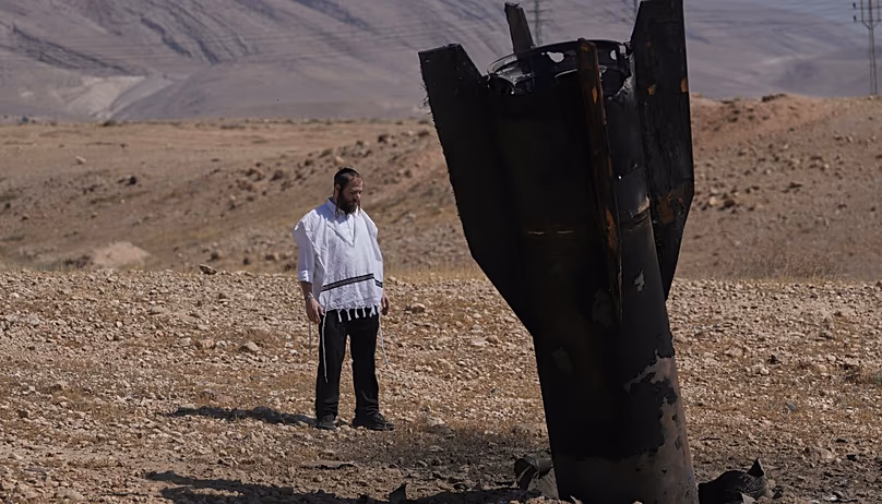 Un homme regarde l’épave d’un missile iranien qui a atterri près de la ville de Jéricho en Cisjordanie, le lundi 8 juin 2026. (AP Photo/Mahmoud Illean)