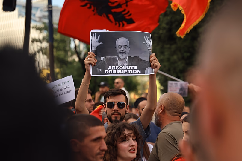Des manifestants brandissant une affiche représentant le Premier ministre Edi Rama participent à un rassemblement à Tirana, le 6 juin 2026.