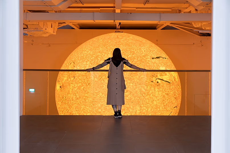 Un visiteur regarde Helios de Luke Jerram, un soleil brillant de six mètres réalisé à partir d'images de la NASA