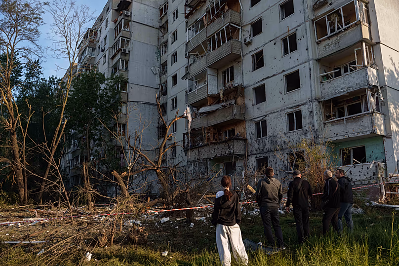 Des gens regardent un immeuble résidentiel endommagé après une frappe russe à Kiev, le 2 juin 2026.