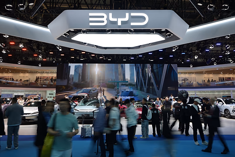 Les visiteurs visitent le stand du constructeur automobile chinois BYD avec un écran montrant sa station de charge de batterie sous des températures inférieures à zéro - Auto China 2026, Pékin, avril 2026.
