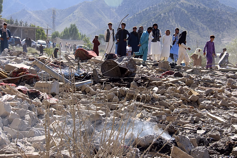 Des habitants marchent parmi les décombres après ce que les responsables talibans ont qualifié de frappes aériennes pakistanaises dans le village de Mandokhail, le 29 juin 2026.