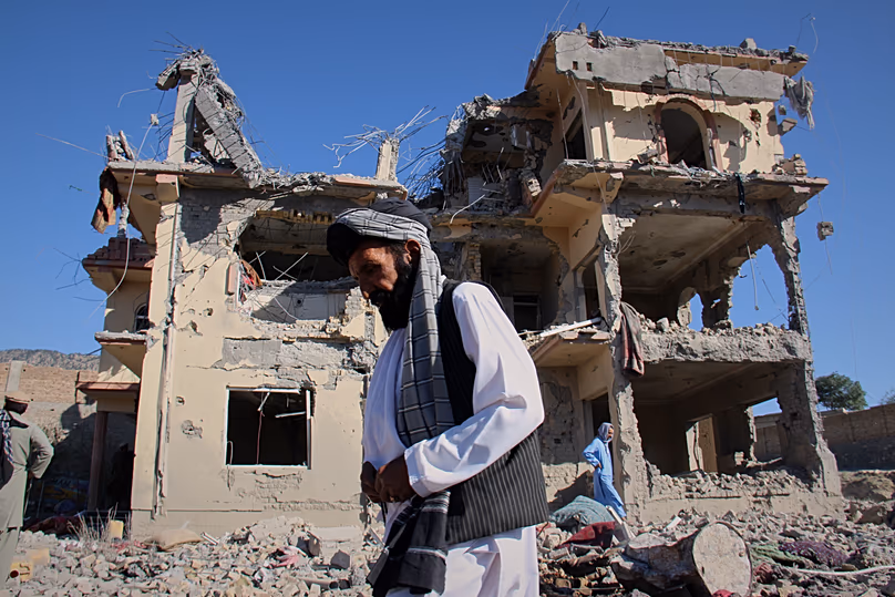 Des habitants marchent parmi les décombres après ce que les responsables talibans ont qualifié de frappes aériennes pakistanaises dans le village de Mandokhail, le 29 juin 2026.