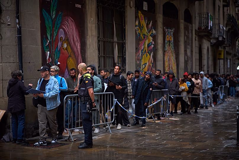 Des migrants font la queue devant l'hôtel de ville de Barcelone pour obtenir les documents nécessaires pour demander l'amnistie espagnole en matière d'immigration, le 29 avril 2026.