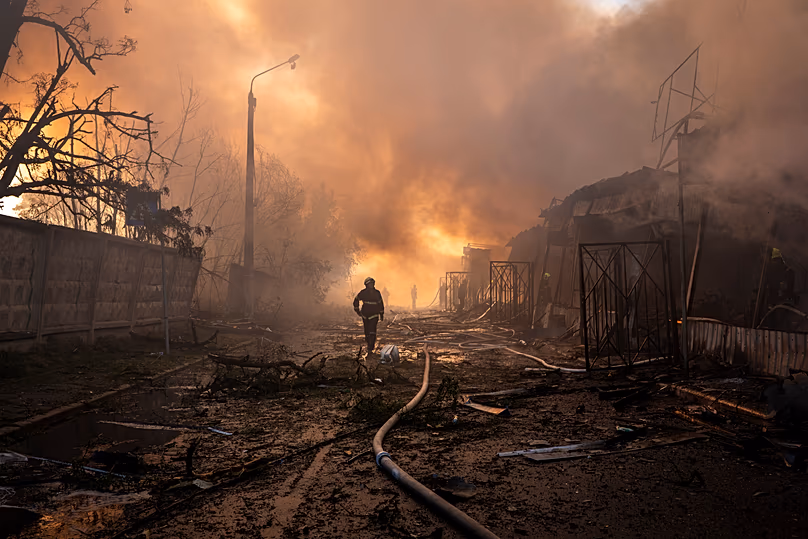 Des pompiers tentent d'éteindre un incendie sur un marché de la ville à la suite d'une attaque de missiles et de drones russes à Kiev, le 15 juin 2026.