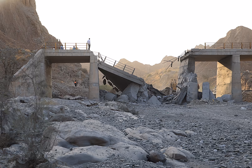 Des personnes se tiennent sur un pont détruit après une frappe dans la province d'Hormozgan, dans le sud de l'Iran, le samedi 18 juillet 2026.