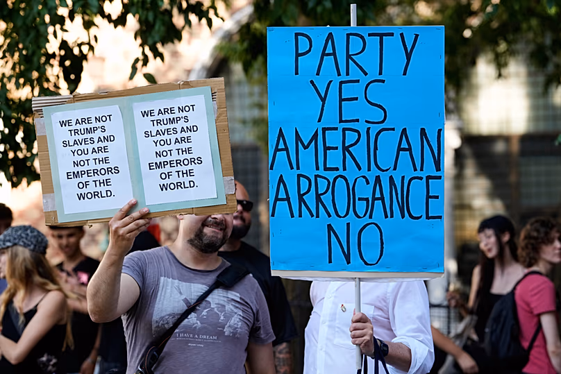 Des manifestants brandissent des banderoles alors qu'ils se rassemblent pour protester contre la présence du superyacht « Boardwall » de l'ambassadeur américain Tilman Fertitta à Venise, le vendredi 17 juillet 2026.