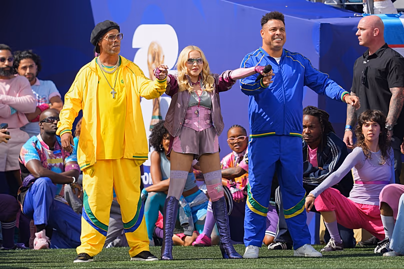 Le monde à leurs pieds : Ronaldinho, à gauche, et Ronaldo aux côtés de Madonna alors qu'elle se produit lors du spectacle de la mi-temps de la finale de la Coupe du monde entre l'Espagne et l'Argentine au New Jersey