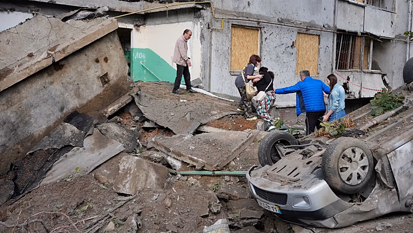 Des habitants marchent au milieu des débris suite à une attaque de missile russe à Kiev, le 6 juillet 2026