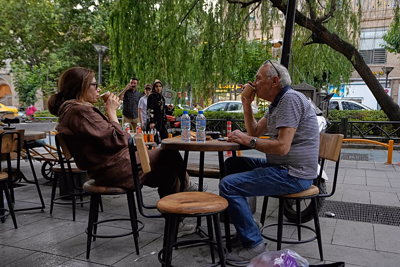 Les gens boivent du café dans la salle à manger en plein air d'un café près du vieux bazar principal de Téhéran, Iran