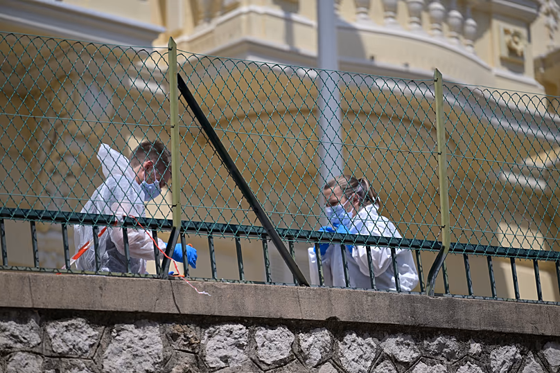 Les enquêteurs examinent les lieux de l'immeuble résidentiel où un engin explosif a grièvement blessé trois personnes la veille à Monaco, le 30 juin 2026.