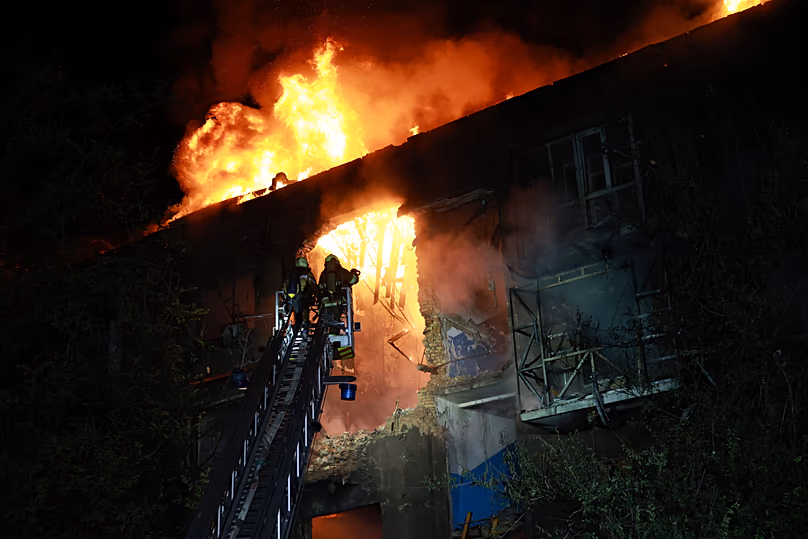 Des secouristes tentent d'éteindre l'incendie d'un immeuble résidentiel en feu après une attaque de drone russe sur Zaporizhzhia, en Ukraine, dimanche soir 12 juillet 2026.