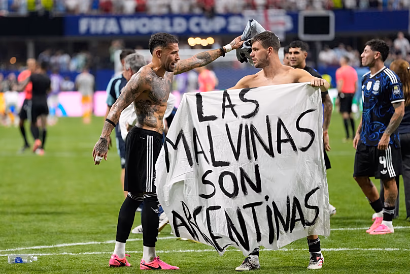 Giovani Lo Celso, de l'Argentine, tient une bannière avec les mots "Les Malvinas sont argentines"à l'issue du match de demi-finale de Coupe du monde contre l'Angleterre à Atlanta, le 15 juillet 2026.