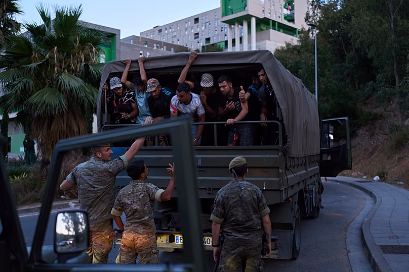 Migrants who crossed into Spain are escorted by Spanish soldiers towards the Spanish-Moroccan border for their return to Morocco on 2 August 2026.
