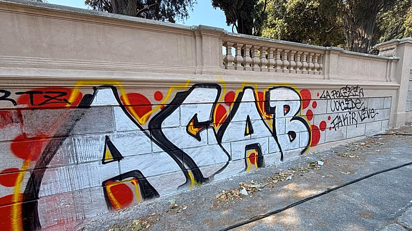 Un mur à l'extérieur de la Villa Sciarra, à Rome, couvert de graffitis avant le traitement de Tuveri