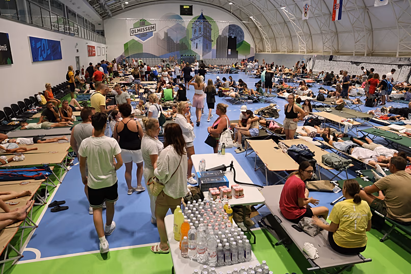 Des habitants et des touristes évacués suite à un incendie de forêt se rassemblent dans une salle de sport à Omiš, le 14 août 2026.