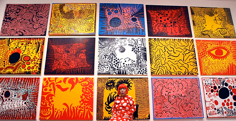 L'artiste japonaise Yayoi Kusama pose avec ses œuvres à la Tate Modern de Londres avant son exposition de 2012. Mardi 7 février 2012.