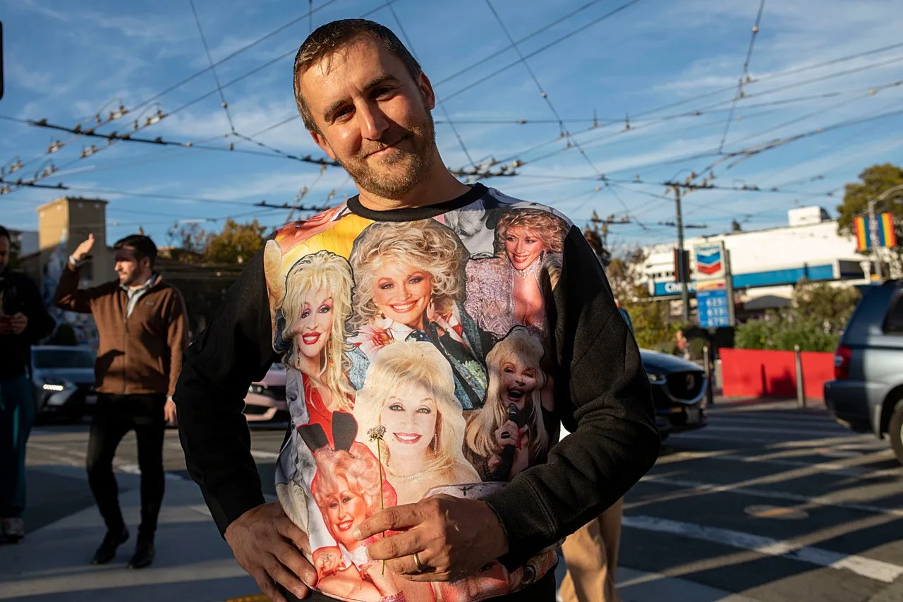 Un fan de Dolly Parton se rassemble pour célébrer la vie de la chanteuse country au Harvey Milk Plaza dans le quartier Castro de San Francisco le mardi 25 août 2026.
