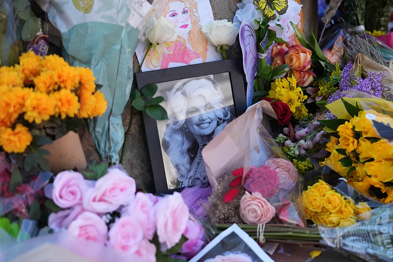 Des images et des fleurs forment un mémorial de fortune honorant Dolly Parton devant sa statue à Sevierville, Tennessee, le 25 août 2026.