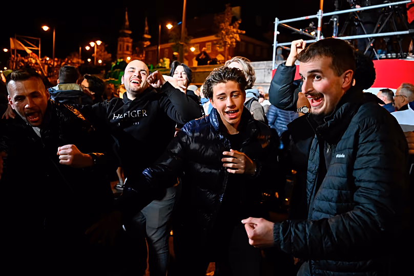 People celebrate in the streets following the announcement of the partial results of the parliamentary election, in Budapest, Hungary, Sunday, April 12, 2026. (AP Photo/Denes