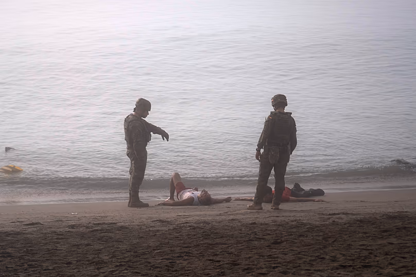 Spanish army soldiers alongside migrants who swam from Morocco to the Spanish enclave of Ceuta, Saturday 1 August 2026.