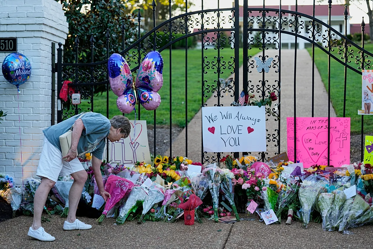 Un fan dépose des fleurs pour un mémorial de fortune en l'honneur de Dolly Parton devant sa maison, le 25 août 2026, à Brentwood, Tennessee.