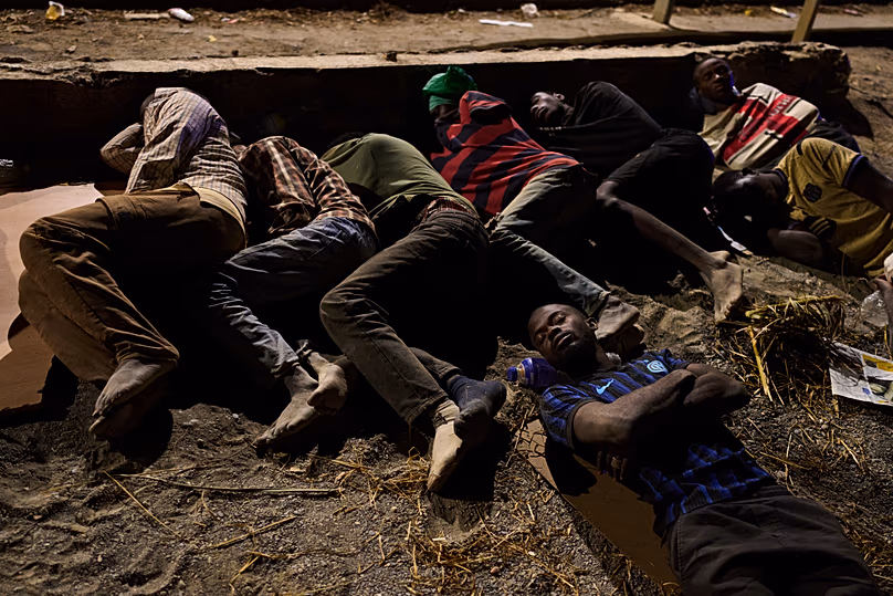 Des migrants arrivés en Espagne depuis le Maroc dorment sur une plage de l'enclave espagnole de Ceuta, le lundi 3 août 2026. (AP Photo/Bernat Armangue)