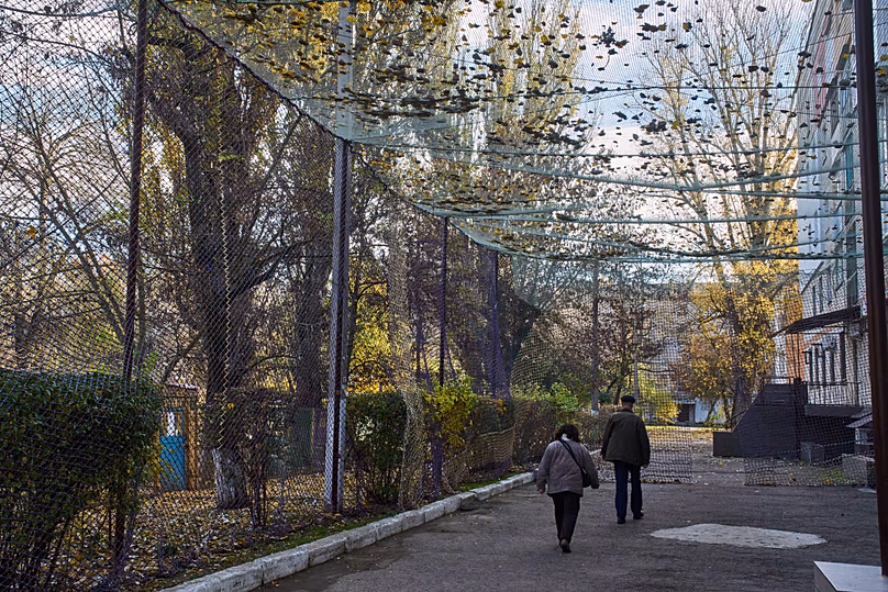 DOSSIER : Des résidents locaux marchent le long d'une rue couverte d'un filet anti-drone FPV dans la ville de première ligne de Kherson, dans le sud de l'Ukraine, le lundi 3 novembre 2025.